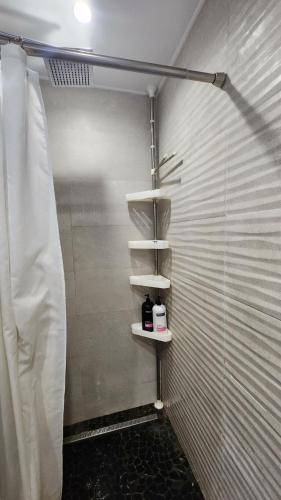a walk in shower with white walls and shelves at Coconest - Duplex on the beach in Baie Nettle