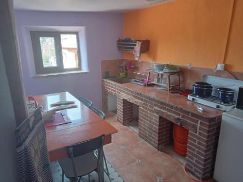 a kitchen with a brick fireplace and a table at Albergue de peregrinos Casa Nostra in Castrojeriz