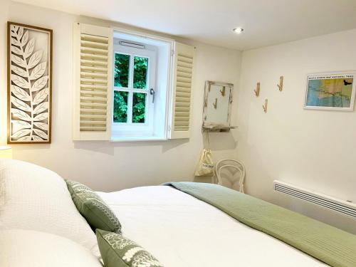 a bedroom with a bed and a window at The Stables at The Forge Self Contained Apartment in Pyecombe