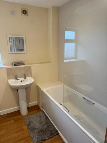 a bathroom with a sink and a bath tub and a sink at Modern, Quiet, Sleeps 9, Etihad, CoOp Live, Manchester in Manchester