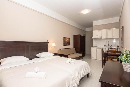 a hotel room with two beds and a kitchen at Talos Hotel Apartments in Kato Daratso