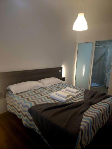 a bedroom with a bed with two towels on it at A Trajadinha do Lima in Ponte de Lima