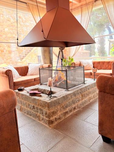 a living room with a fire pit in the middle at CASA VASARI Holiday Suites TUSCANY in Lucignano