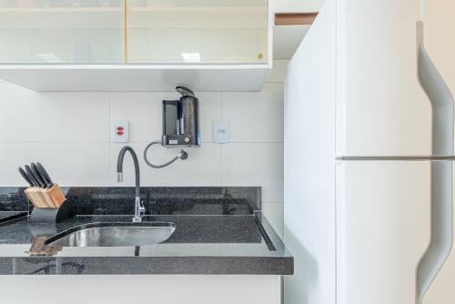 uma cozinha com pia e geladeira em Apartamento Praia Enseada - Guarujá no Guarujá