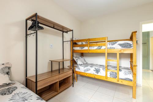 um quarto com dois beliches e uma cama em Apartamento Praia Enseada - Guarujá no Guarujá