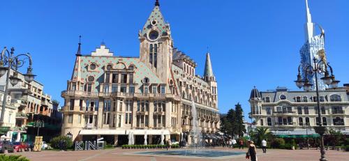 a large building with a fountain in front of it at Апартаменты Батуми первая линия in Batumi