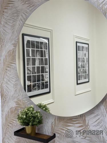a hallway with a circular mirror and a table with a plant at IN Piazza Apparthotel in Poggiomarino