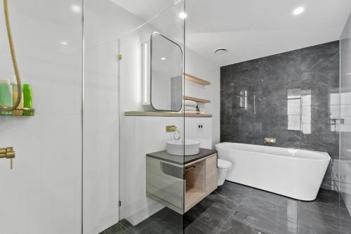 a bathroom with a white tub and a sink at Sky-High Villa with Wide Ocean Views - Pet Friendly in Gold Coast