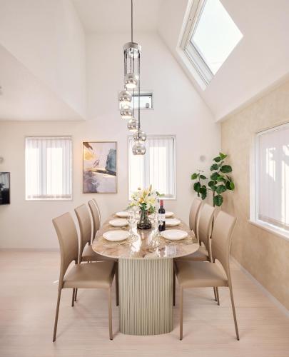 a dining room with a table with chairs and a chandelier at LUXU Urban Shinjuku - 4min to Shinjuku, 10min to Shibuya in Tokyo