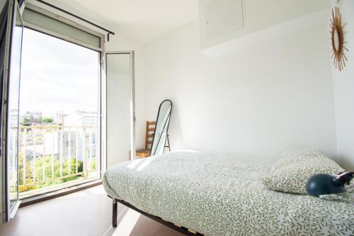 une chambre avec un lit et une grande fenêtre dans l'établissement Le République I Centre Ville & Vue mer, à Brest