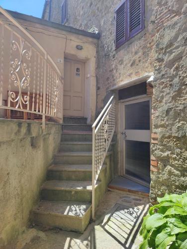 a set of stairs leading to a building with a door at Sassolina house bike in Sassofortino