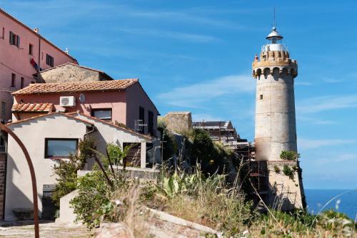 a lighthouse on a hill next to a building at Delizioso Loft a Forte Stella, Isola d'Elba in Portoferraio