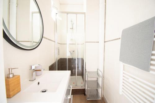 une salle de bain avec un lavabo et un miroir dans l'établissement Le République I Centre Ville & Vue mer, à Brest