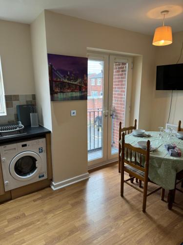 a kitchen and dining room with a table and a washing machine at Modern, Quiet, Sleeps 9, Etihad, CoOp Live, Manchester in Manchester