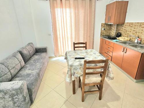 a living room with a couch and a table and a kitchen at Center Apartments in Ksamil