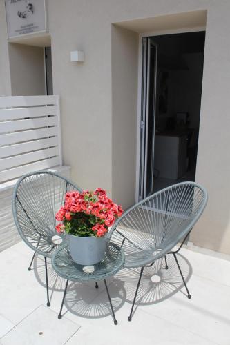 two chairs and a table with a pot of flowers at Encanto Suites by La Sirenetta in Taormina