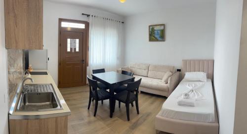 a kitchen and a living room with a table and a couch at Vila Martini in Vlorë