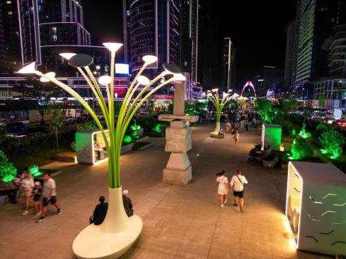 a group of people walking around a city at night at Апартаменты Батуми первая линия in Batumi