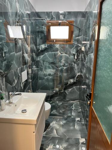 a bathroom with a sink and a toilet at Vila Martini in Vlorë