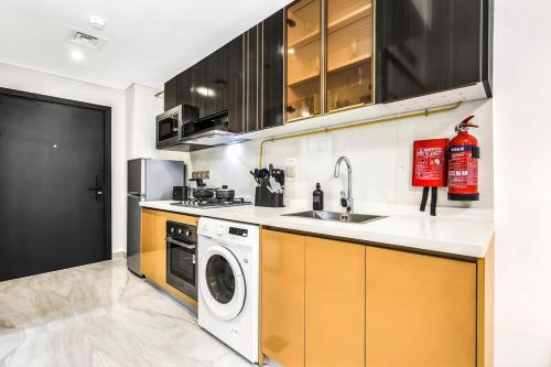 a kitchen with a sink and a washing machine at Dubai Studio Retreat Pool, Gym, Balcony & Queen Bed for Two in Dubai