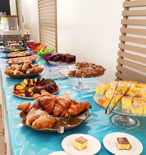 a table with many different types of pastries and pies at Hotel Cà Vanni in Rimini