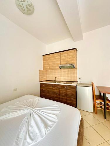 a bedroom with a white bed and a kitchen at Vila Mare in Shëngjin