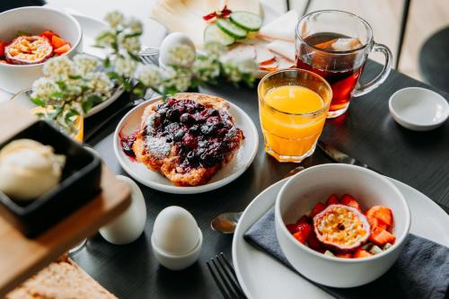 ein Tisch mit Tellern voller Essen und Getränke in der Unterkunft Boutique B&B Oud Aa in Breukelen
