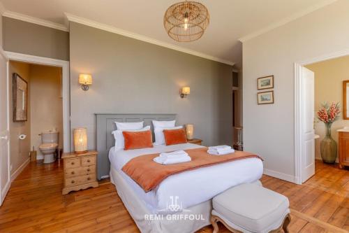 une chambre avec un grand lit avec des oreillers orange dans l'établissement La Tour de l’Estuaire Sea View & Shared Garden 6 guests, à Honfleur