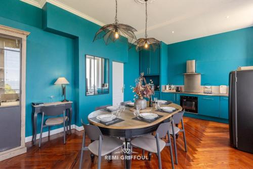 une salle à manger avec des murs bleus et une table et des chaises dans l'établissement La Tour de l’Estuaire Sea View & Shared Garden 6 guests, à Honfleur