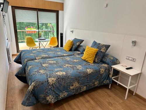 a bedroom with a bed and a table and chairs at El Malecon in Sarria