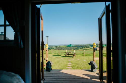 an open door with a view of a field at Nirvana Glamping in Tiverton