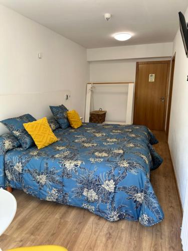 a bedroom with a blue bed with yellow pillows at El Malecon in Sarria
