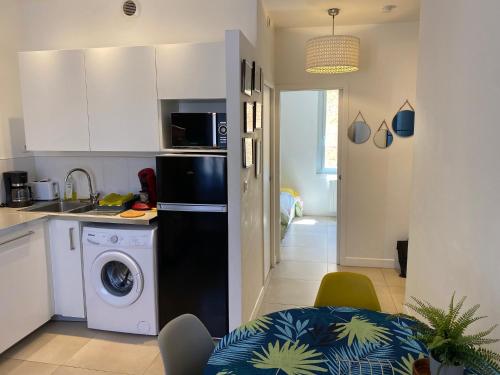 La cuisine est équipée d'un réfrigérateur noir et d'un lave-vaisselle. dans l'établissement P3, 2 bedrooms, quiet, Montpellier city center, à Montpellier