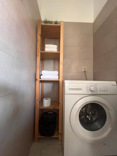 a laundry room with a washing machine and a wooden shelf at Kay Soley La in Saint-François
