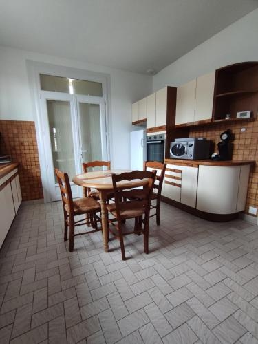 une cuisine avec une table et des chaises dans une pièce dans l'établissement Maison au calme dans Bergerac proche du centre et des services, à Bergerac