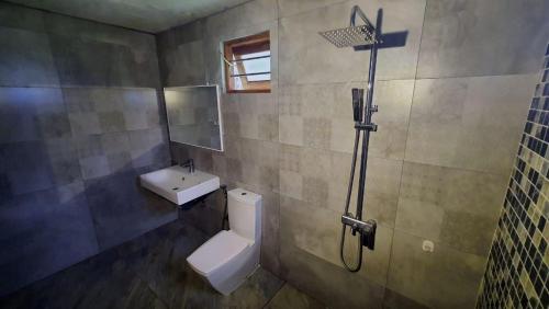 a bathroom with a toilet and a sink and a shower at Peace Villa - Homestay in Dickwella