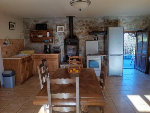 une cuisine avec une table en bois et un réfrigérateur dans l'établissement appartement en pleine nature avec terrasses, à Sablières