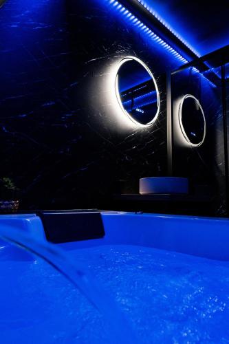 une piscine avec deux fenêtres et une lumière bleue dans l'établissement DARK ROOM - Suite Luxueuse près de la mer, à Villers-sur-Mer