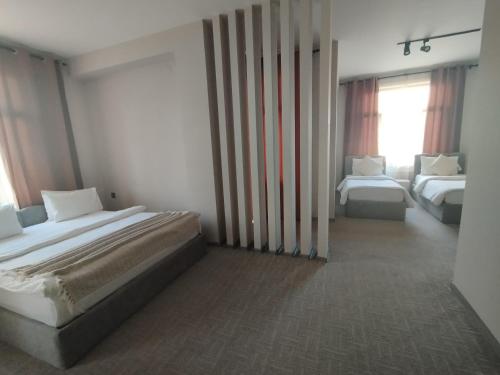 a hotel room with two beds and a window at Dastan Hotel Baku in Baku