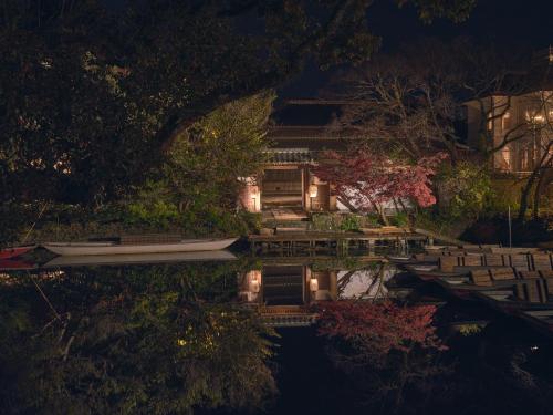 a house with a boat in the water at night at Ohana in Yanagawa