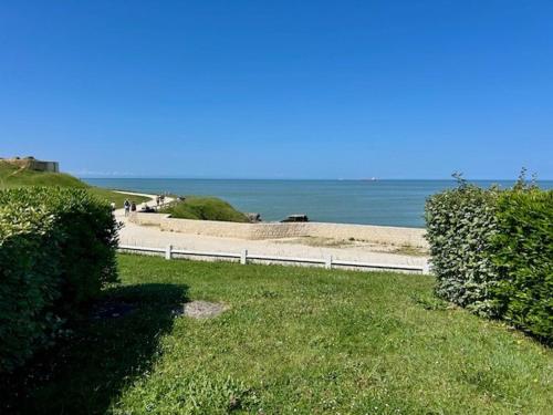 einen Weg zum Strand mit dem Ozean im Hintergrund in der Unterkunft Appartement en bord de mer avec jardin, parking et animaux acceptés à Royan - FR-1-494-63 in Royan