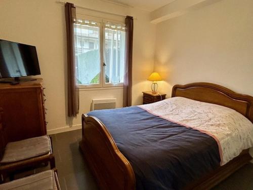 une chambre avec un lit, une télévision et une fenêtre dans l'établissement Appartement 5 personnes près plage Nauzan avec terrasse, animaux acceptés - FR-1-494-210, à Vaux-sur-Mer
