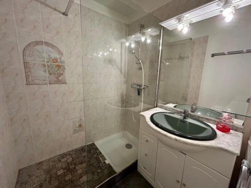 La salle de bains est pourvue d'un lavabo vert et d'une douche. dans l'établissement Appartement 5 personnes près plage Nauzan avec terrasse, animaux acceptés - FR-1-494-210, à Vaux-sur-Mer