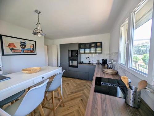 une cuisine avec un comptoir, une table et des chaises dans l'établissement vue mer grande terrasse plage à 2 min à pieds, à Sanary-sur-Mer