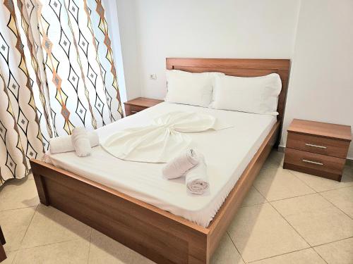 a bed with two pairs of slippers on it at Center Apartments in Ksamil
