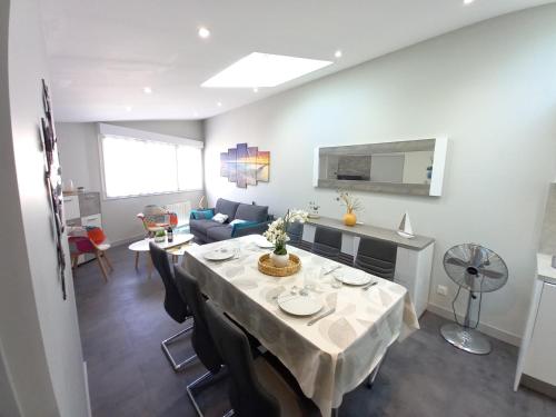 a dining room with a table and a living room at Saint Georges de Didonne - TOUT CONFORT et TOUT A PIED - APPARTEMENT au TOP in Saint-Georges-de-Didonne