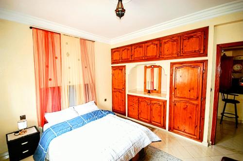 a bedroom with wooden cabinets and a bed in it at Appartement Vintage full équipé EL JADIDA in El Jadida