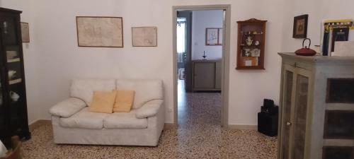 a white chair with a yellow pillow in a living room at Atina House - Centro Storico in Atina