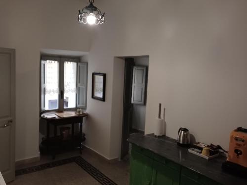 a kitchen with a counter and a table and a window at Atina House - Centro Storico in Atina