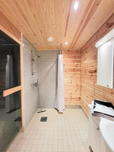 a bathroom with a shower in a wooden ceiling at Vaskooli Apartments in Loimaa